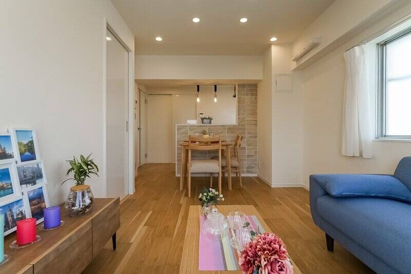 床材には、表面に天然木をあしらった突板のフローリングが採用されています。素足で歩くと気持ちよさそう！キッチンの腰壁にはタイル貼りが施されており、空間のアクセントになっています。