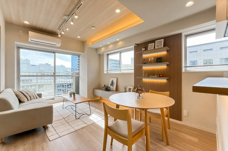 約12帖のLDK。南東と南西の二面に窓がある開放的な空間。木目調の天井や間接照明がくつろぎの時間を演出してくれます。