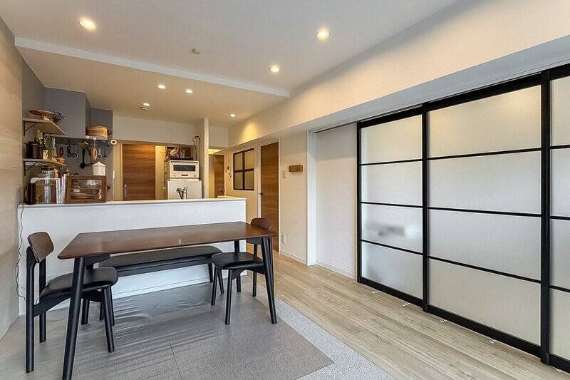 ホワイトとグレーを基調にした、約12.2帖のLDK。隣接する洋室Aを仕切る引き戸のブラックのフレームが、空間の雰囲気をグッと引き締めてくれていますね。