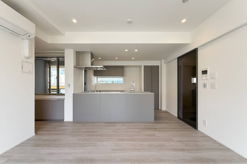 造作ソファの対面にはEIDAI製のキッチン。角が目立つフォルムで建具や腰壁はグレーで統一され、全体的にスタイリッシュな雰囲気です。