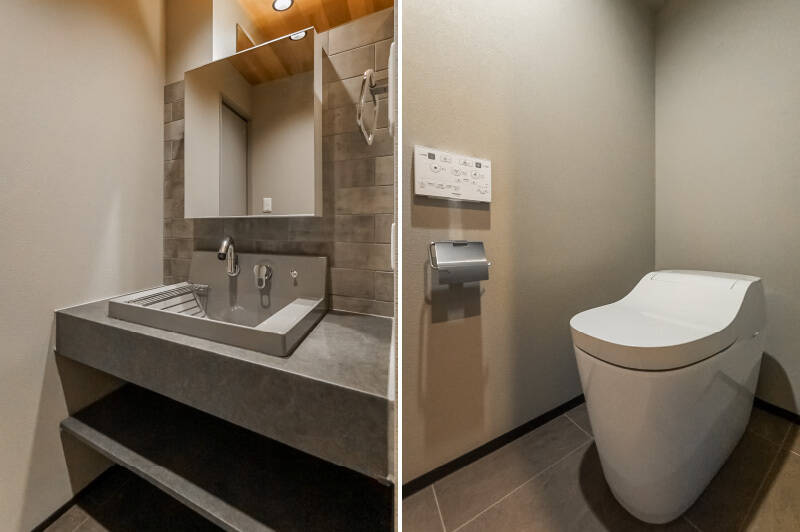 <b>左・</b>洗面室は扉がなく玄関横に位置するため、帰宅後すぐに利用できます。洗面ボウルまでグレーで統一され、色味の一体感があります。／<b>右・</b>タンクレスのトイレですっきりとした印象。