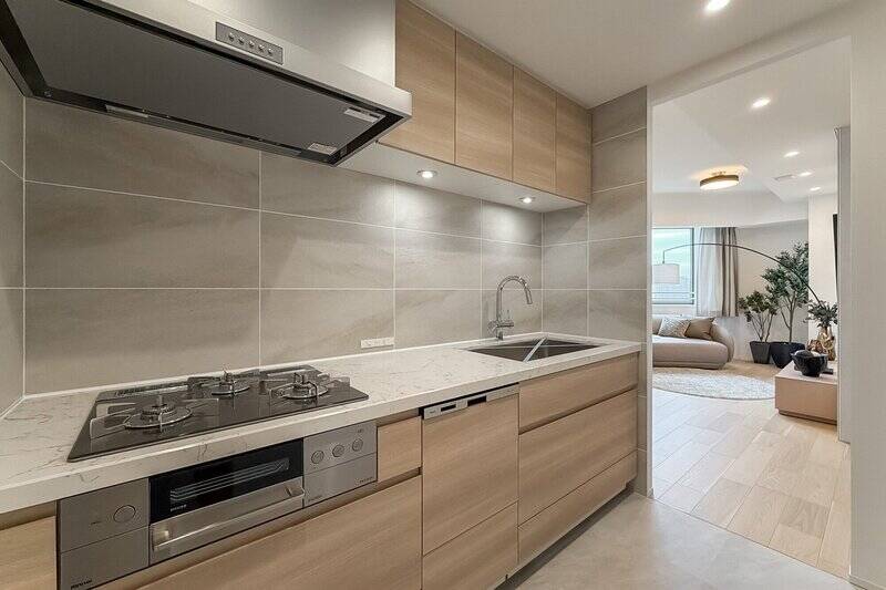 LDからの動線を確保しつつ、ほどよく独立性があるキッチン。3口コンロや食洗機、浄水器付き水栓に加え、シンクにはディスポーザーを完備。