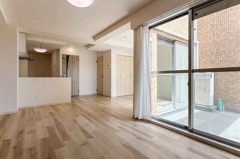 バルコニーを囲むように配されたリビングダイニング。右手奥に折れ戸2枚分の収納を備えています。