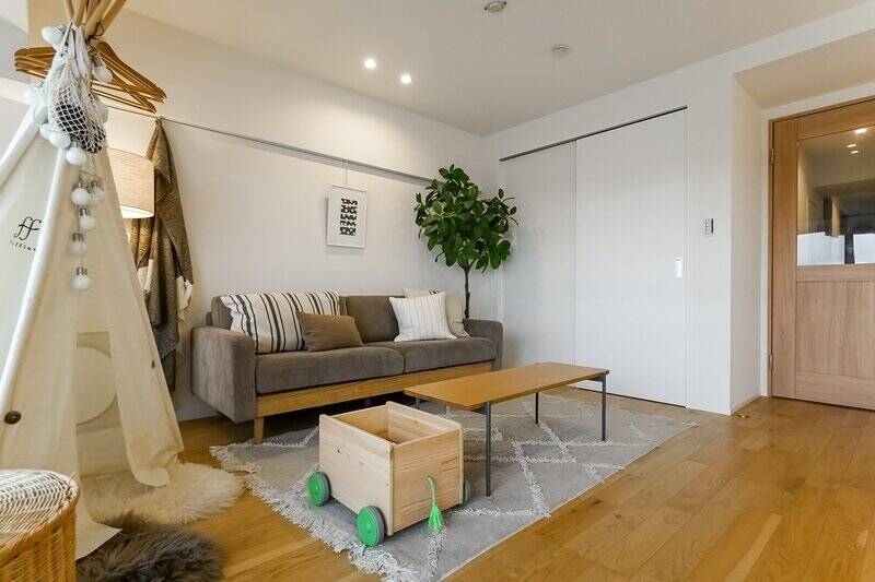 大きめのソファ、お子さまの遊具を設置できる広さ。奥にはウォークインクローゼット（WIC）があります。