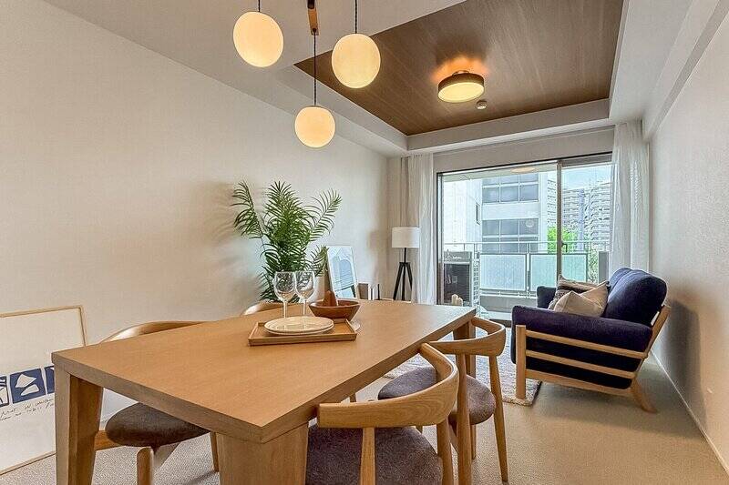 まずは約14.2帖のLDKから。南西向きのバルコニーから穏やかな光が差し込み、ベージュのクロスとライトブラウンのカーペットが空間全体を包み込んでいます。