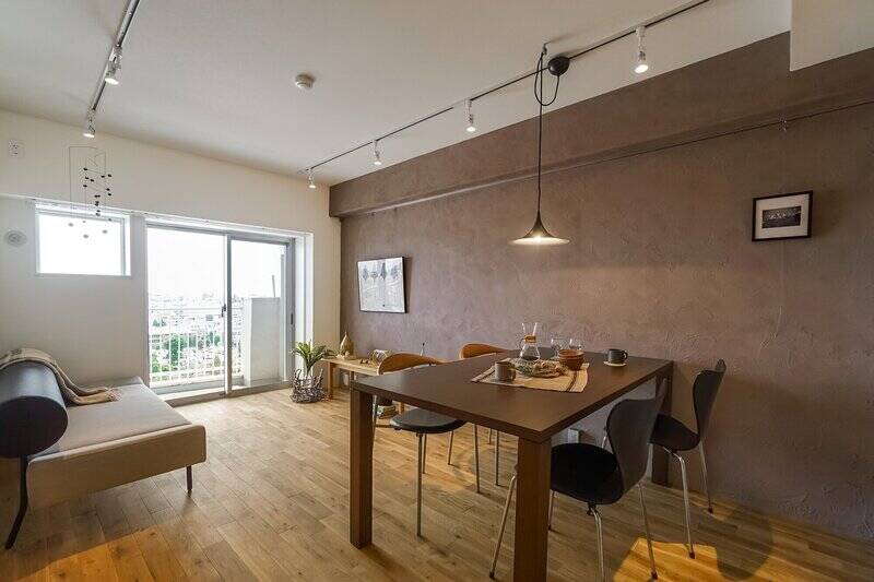 さて。眩しい光が射し込む、約12.3帖のLDKにやって来ました。足元はホワイトオークの無垢フローリング貼り。壁面は、アクセントとしてカフェラテカラーのシリカライム塗装で仕上げられています。