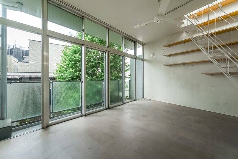 階段を下りて、約14帖のLDKにやってきました。天井までの高さのある大きな窓がかっこいい！ 窓の向こうには南東向きのバルコニーがあり、植栽のグリーンが暮らしに潤いを添えてくれます。