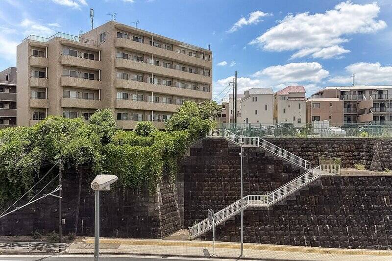 正面には、国道246号を挟んで擁壁があり、その上には建物が立地しています。左右へ視線を向けると、視界が抜ける角度もありますよ。