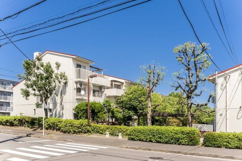 東急田園都市線・横浜市営地下鉄ブルーライン「あざみ野」駅から歩くこと13分。青々とした木々が美しく、どこかノスタルジックな雰囲気を残す、1982年竣工の団地にやってきました。複数区画ある大規模な団地ですが、今回ご紹介する住戸はその中でも駅寄りのポジション。さらに、徒歩2分の場所には「あざみ野」駅方面へのバスが発着する「あざみ野団地」停留所があります。雨の日や荷物の多い日にも心強い味方になってくれますよ。