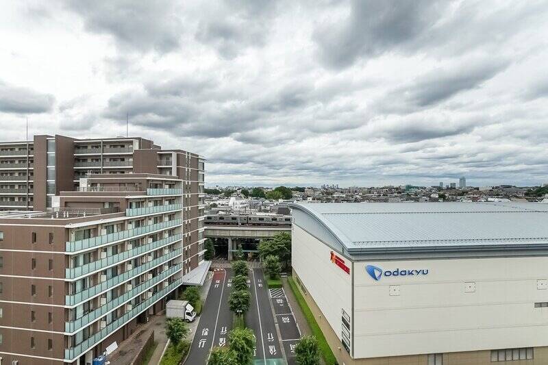 周辺の建物とは距離が保たれており、圧迫感のないのびやかな景色が広がります。視線の先、建物の合間からのぞくのは線路。