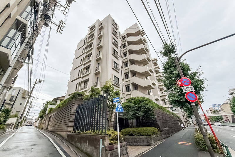 1985年築で新耐震基準を満たした、全21戸の小規模なマンションです。機械式駐車場へと入るシャッターは目黒通り沿いに設置されています。 