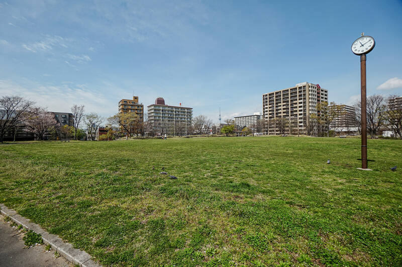 今回の物件のストロングポイントは、公園と最寄り駅が近いこと! 「わんさか広場」は道路を挟んで目の前のロケーション。写真の中央左に見えているのが、今回ご紹介するマンションです。