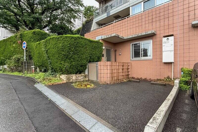 マンションの裏手から直接住戸にアクセスが可能！ この住戸に付帯する、<b>専用使用権付きの駐車場</b>の隣に玄関扉が。大きめのお車も駐車できそうですよ。