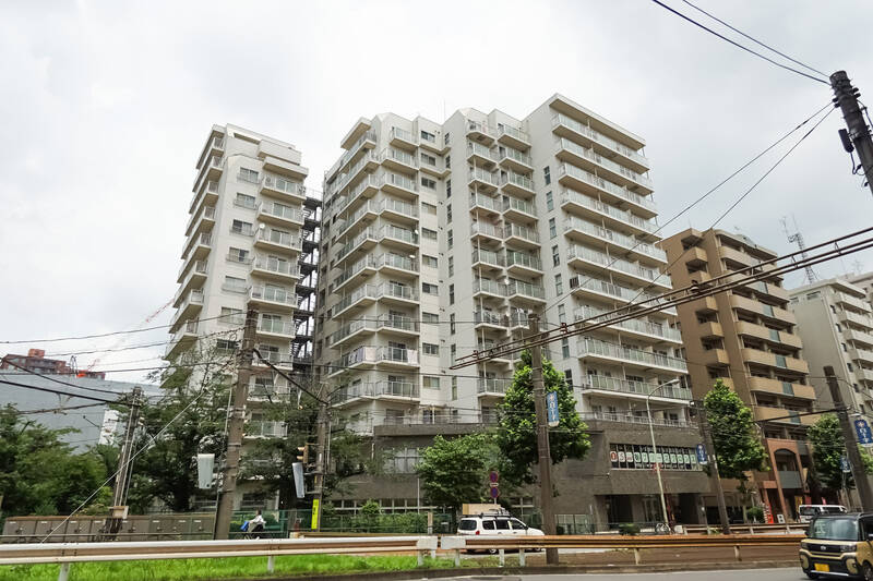 それでは建物全景をどうぞ。明治通りと新目白通りが交差する角地に建つ、1981年竣工・総戸数99戸のマンションです。白塗りの外観や共用部は、こまめな修繕によって清潔感ある姿に保たれています◎