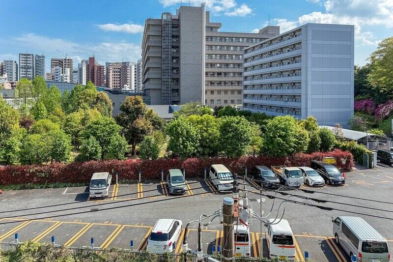 目の前には「NTT関東病院」の建物、その手前には同敷地の駐車場が広がっています。向かいの建物とは距離が取られており、空の広がりも感じられる眺望です。