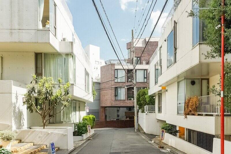 突き当たりに建つ、赤レンガタイル貼りのヴィンテージマンションが目的地。周囲にも有名なマンションが建ち並び、洗練された空気が漂っています。(2021/05撮影)