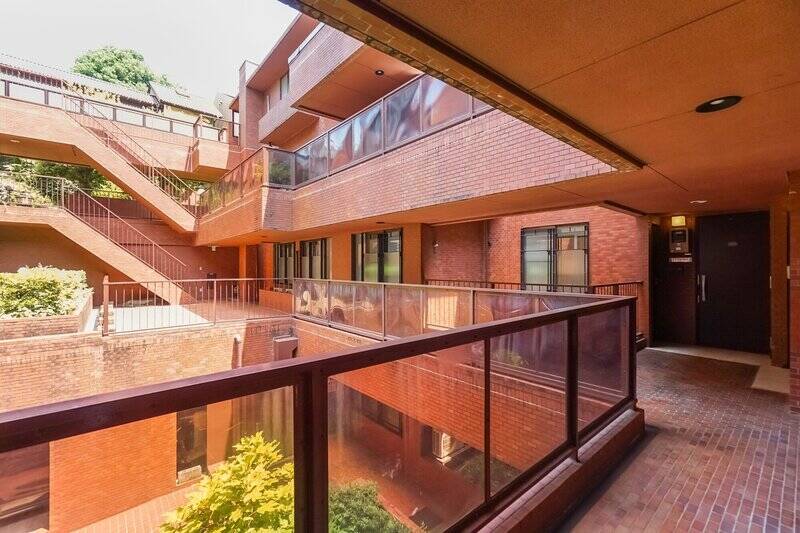 こちらのマンションは建物全体がロの字型をしており、真ん中に大きな吹抜けを抱いています。共用廊下はどこも光と風が入っていい雰囲気！ 写真の右手奥に写っているのが、ご紹介の住戸の玄関扉です。