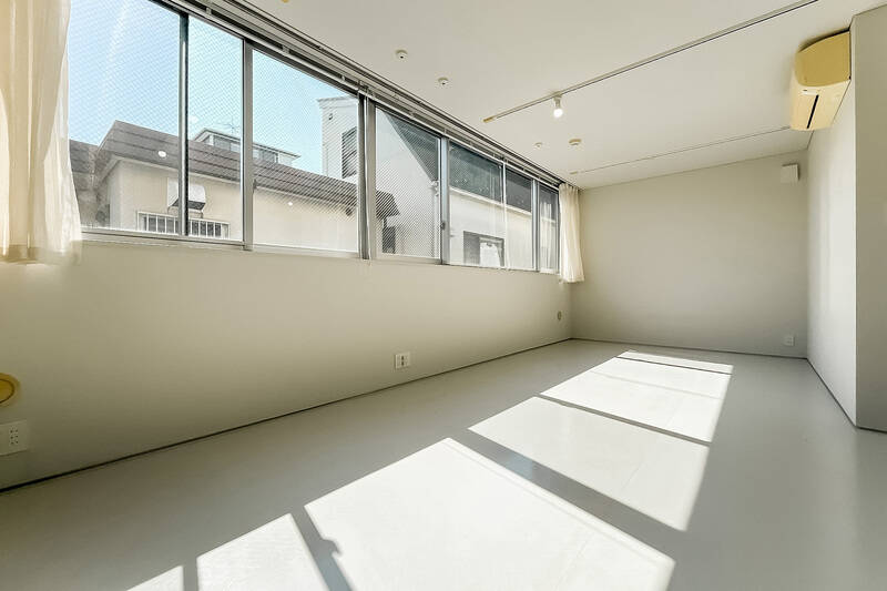 廊下から階段を数段上がった先にある洋室。横幅いっぱいに取られた、南西向きの窓から燦々と陽が差し込みます。