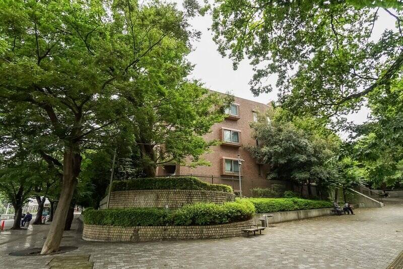 マンションは “御殿山エリア” の緑豊かな丘の上に佇んでいます。2005年に竣工した、地上7階建て・総戸数142戸の重厚感ある建物です。コミュニティを守るように区の保存樹が枝葉を伸ばしており、外からマンションの全容をとらえるのが難しいほど。