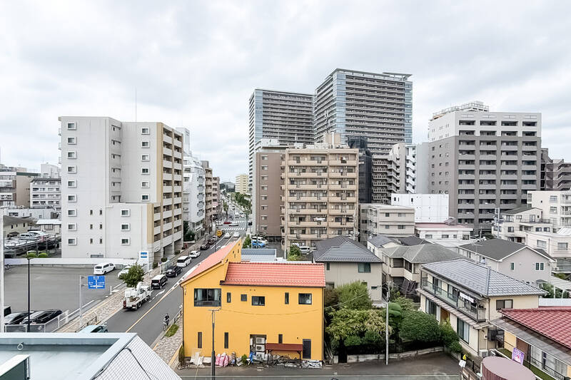 洋室Cからアクセスするバルコニー。周辺には低層住宅が広がり、その先には高層マンションが立ち並ぶ景色。