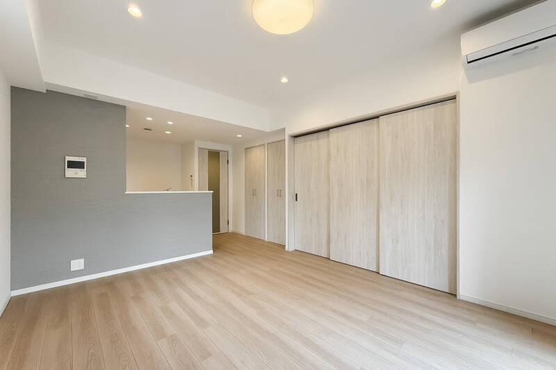 木調の建具に、グレーのアクセントクロスを合わせた空間。引き戸3枚分の先は洋室Aです。それでは開けてみましょう〜。