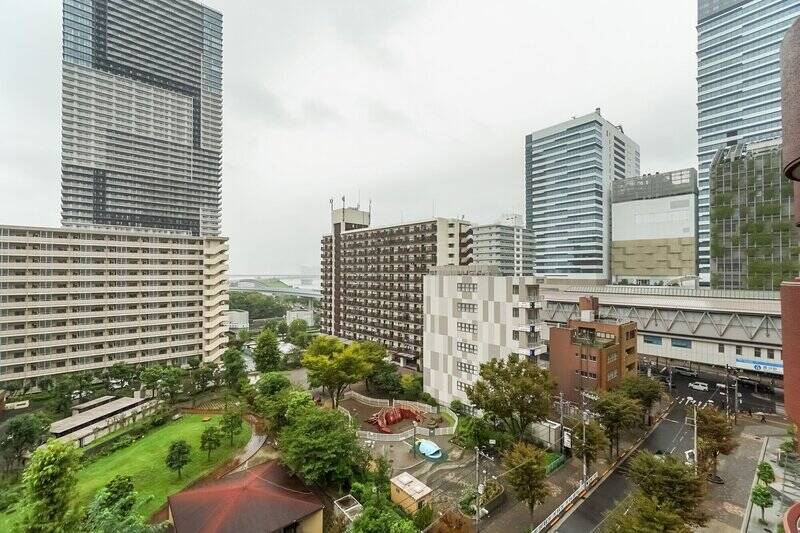 うーん、10階の住戸ならではの清々しい眺めですね！ 右手にはゆりかもめ「豊洲」駅や「アーバンドック ららぽーと豊洲」、眼下にはビルの合間の公園、そして正面奥には東雲運河の水面が見えます。都会的な中にも、自然とうるおいを感じられる景色です。