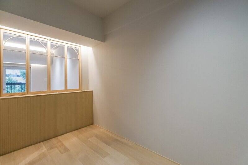 LDKの隣にある洋室にやって来ました。ダブルベッドがちょうど収まるサイズの、休息に特化したスペースです。ヘッドボードが来る部分にはウッドリブパネルがあしらわれており、充電用のコンセントも用意されていますよ。