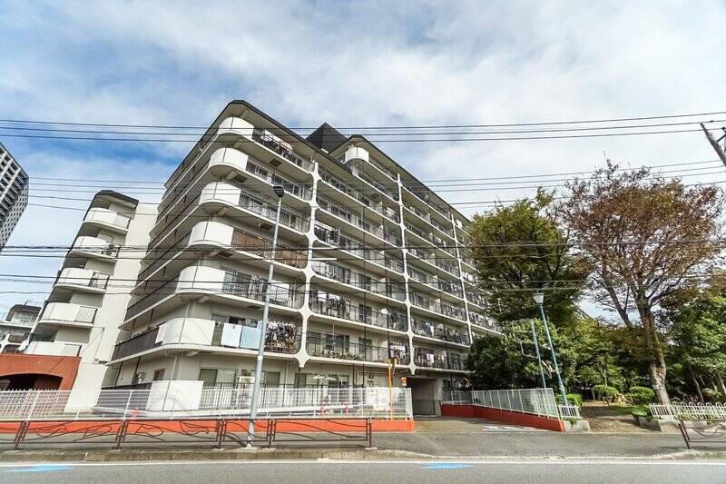 マンションは、全2棟・総戸数341戸のビッグコミュニティです。1982年築とそこそこ築年数は経ていますが、古さを感じさせない清潔感ある佇まい！ 写真右手に写っているのが、バルコニーから見えた「緑の小道」です。