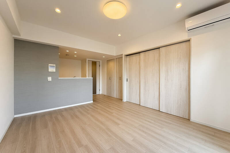木調の建具に、グレーのアクセントクロスを合わせた空間。引き戸3枚分の先は洋室Aです。それでは開けてみましょう〜。